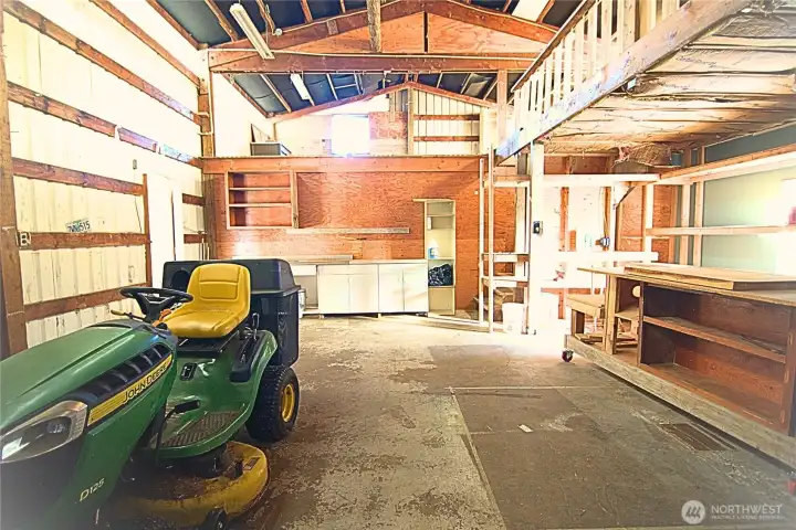 Front view of the shop with work station, stairs to mezzanine and storage above