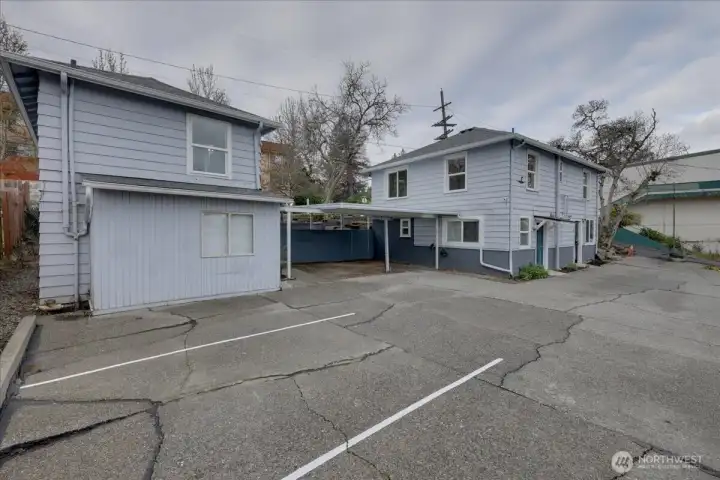Parking area. 2 car carport and 3 open spaces. To lower left, is common laundry room with storage. Above is bedroom to Unit #6. To the right is Unit #1 on top and unit #4 on bottom.
