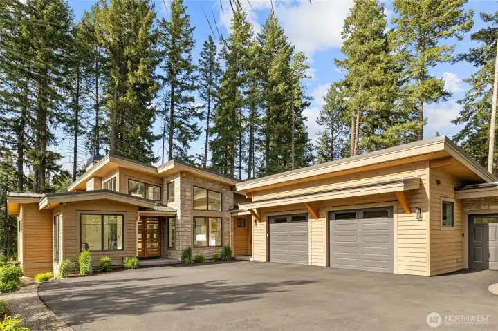 Heated two-car garage offers EV charging & generator hookup. Solar panels, underground irrigation, tankless hot water & dual-zone HVAC ensure efficient living.