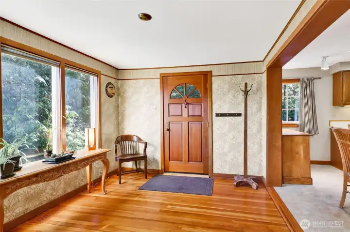 Front door entry with expansive windows flood the home with light and views of the landscaping.