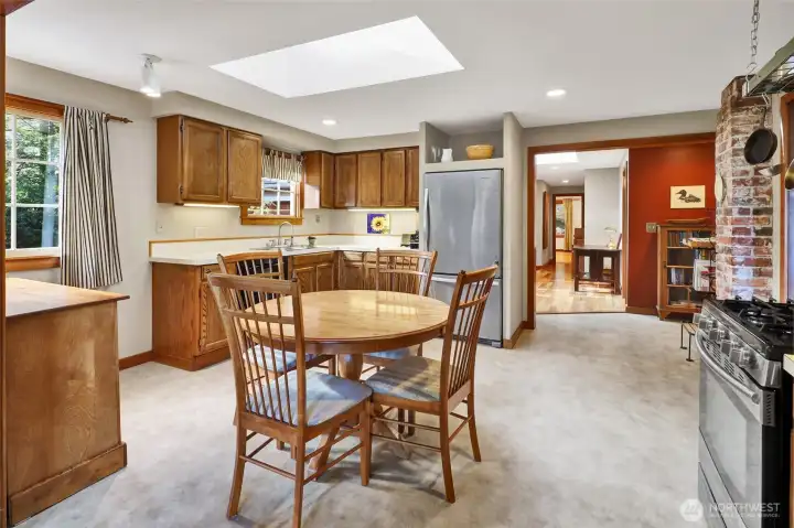 Kitchen with skylight and windows makes for a bright kitchen with dining area. Stainless steel appliances with a gas range.