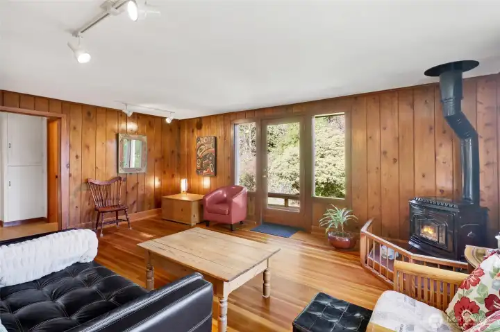 Living room with windows and door leads out to the deck provides great sunlight and inviting views of the natural surroundings.