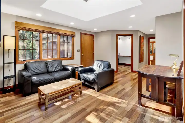 Family room with a large skylights and a wall of windows creates an inviting area to relax.