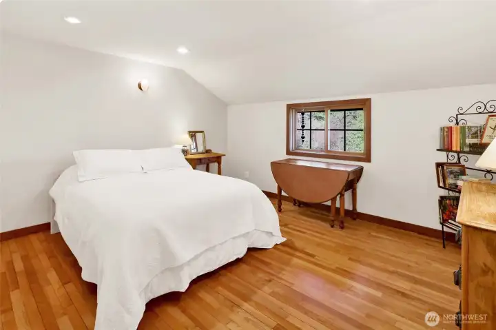 Second bedroom with fir floors and view of the North side of the house with views of the yard.