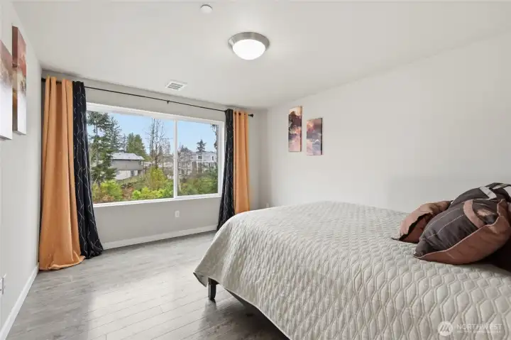 Spacious primary bedroom with view to green space