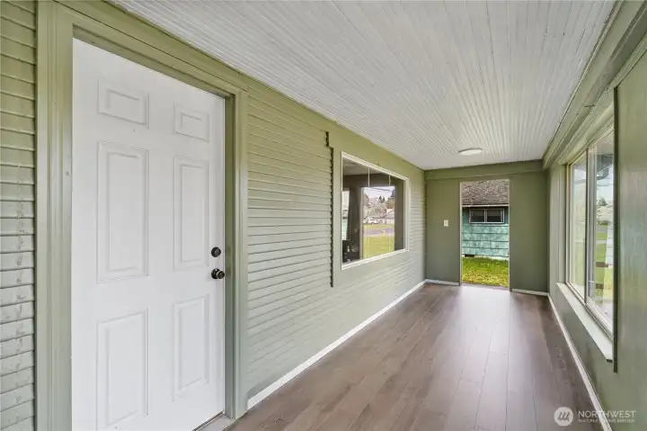 Enclosed front porch and front door.