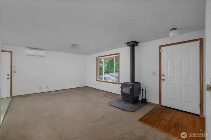 Comfortable living room with wood stove, mini-split for efficient A/C, and easy one-level living.