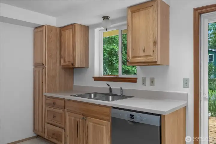 Clean, functional kitchen with updated cabinetry, stainless appliances, and backyard views.