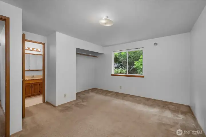 Spacious primary bedroom with direct bath access, closet area, and natural light.