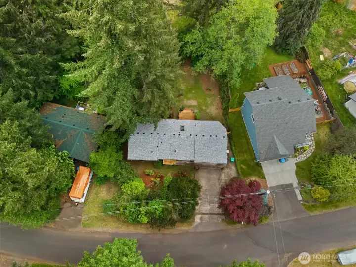 Overhead view showcases the rambler layout, oversized garage, and private backyard setting.