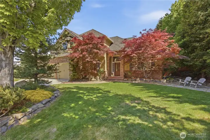 Beautiful front elevation showcasing tall rooflines, welcoming entry, deep triple garage, and manicured landscaping with modern updates throughout.