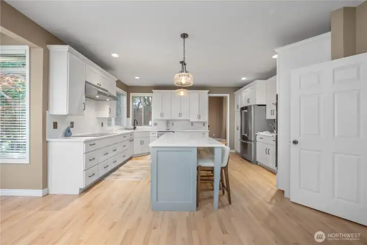 Gourmet kitchen with extensive cabinetry, new dishwasher, microwave, quartz counters, and functional workspace layout.