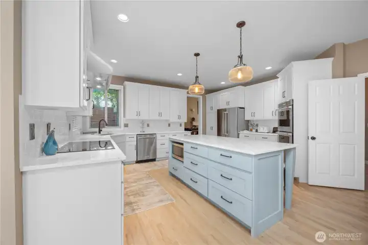 Stylish remodeled kitchen featuring new backsplash, quartz counters, double ovens, pantry storage, and updated modern finishes.
