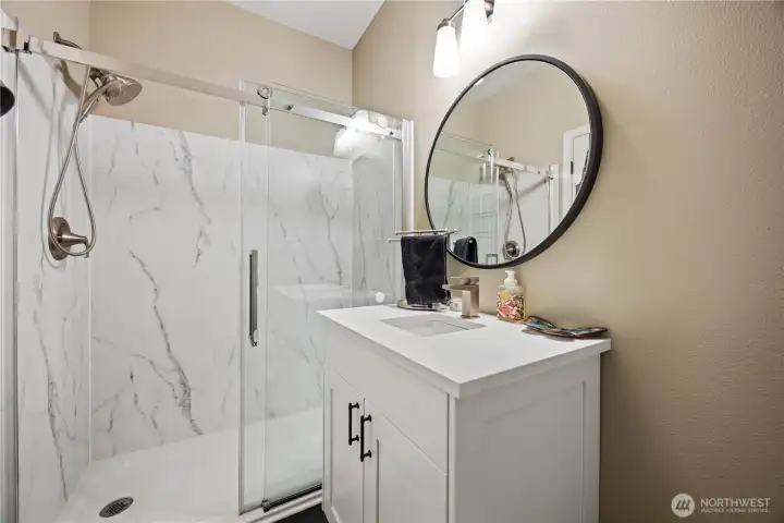 Main-level full bathroom with step-in shower, updated finishes, and convenient accessibility for guests or multigenerational living.