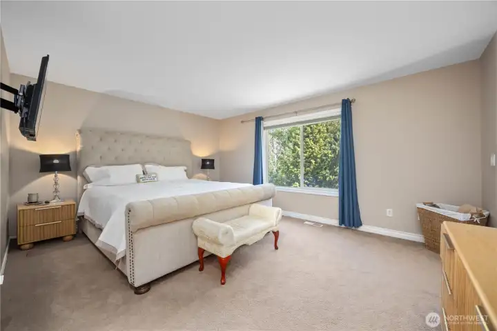 Oversized primary bedroom with abundant natural light, updated finishes, and generous space for seating or additional furniture.