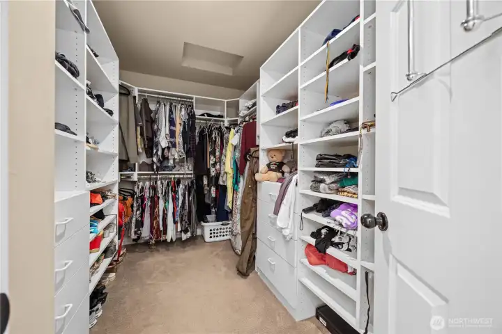 Large primary walk-in closet with custom built-ins, organized storage solutions, and functional layout.