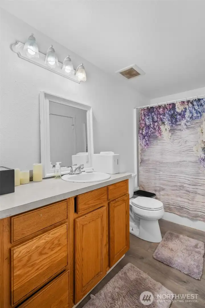 Convenient upper-level full bathroom featuring dual access from both the primary bedroom and the main hallway.