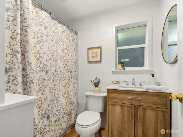 Bathroom has new tile surround, new vanity and charming built-in shelves.