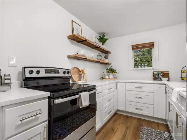 The kitchen has been remodeled with new quartz countertops, white cabinetry, new sink and new appliances.