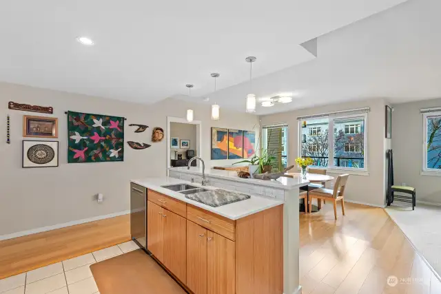 The view from the Kitchen showing the updated Bamboo Cabinetry on the Island, and outlook to the Dining space.   In the background is the entry door to the Primary Suite.