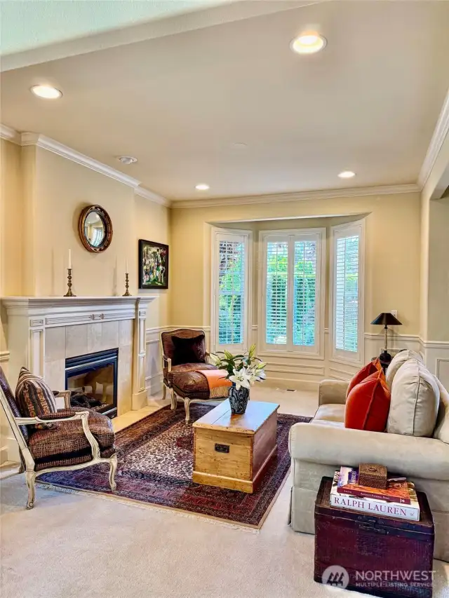 Living room with bay window and gas fireplace.
