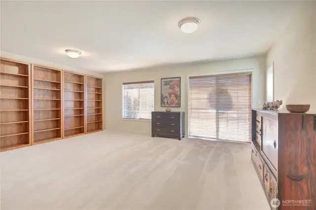 Huge media room upper floor with French door access to a balcony in front.