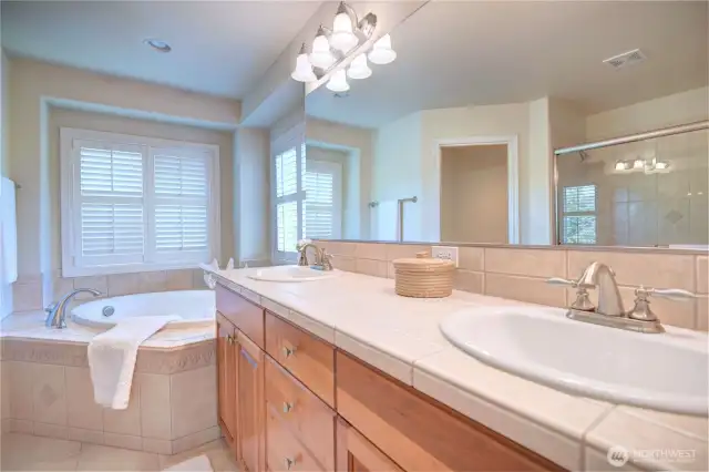 Master suite large tub wraps around with ceramic tiles.