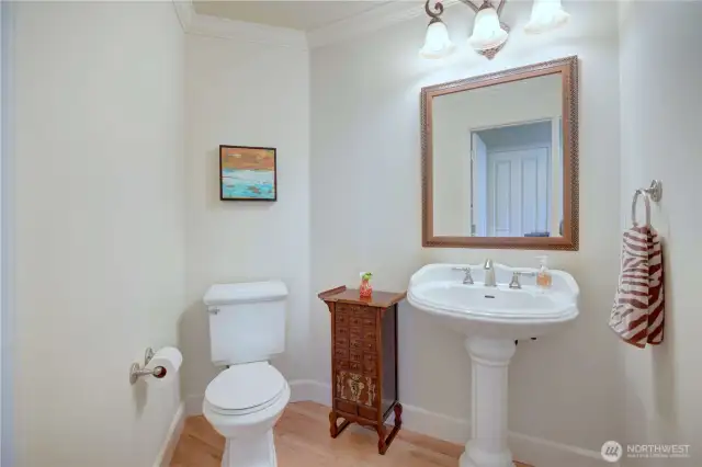 Main floor half bath in the hallway with hardwood floor.