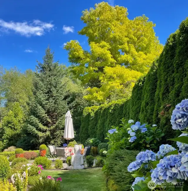 A garden in the backyard with flagstones patio.