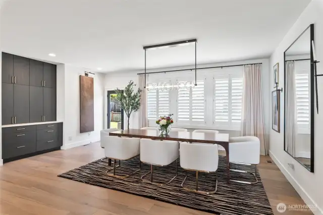Dining room w/ shutters and doorway to rear outdoor living space; Built ins