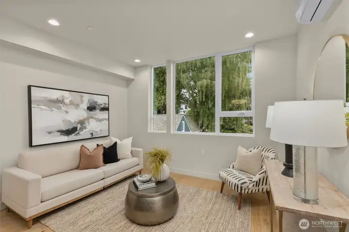 A neutral color palette, oversized windows, and warm wood floors make this space both elegant and inviting.