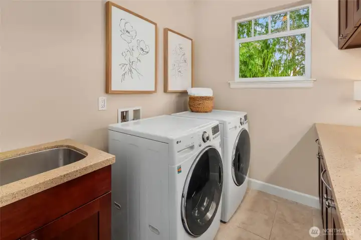 Upstairs laundry room with storage and sink