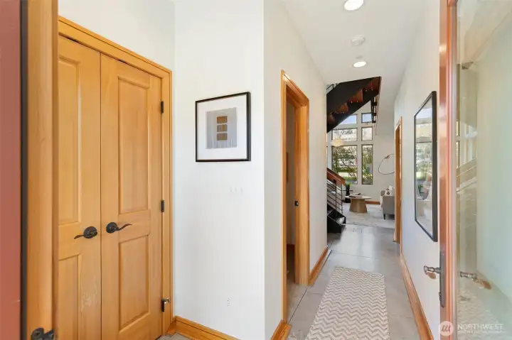 Welcoming entry with warm wood-trimmed doors, radiant heated concrete floors, and a view straight through to the light-filled living area beyond.