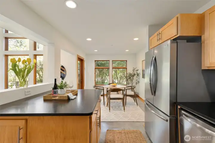 The heart of the main floor — dining, kitchen, and living all connected, with the fireplace and patio door visible from a single vantage point.
