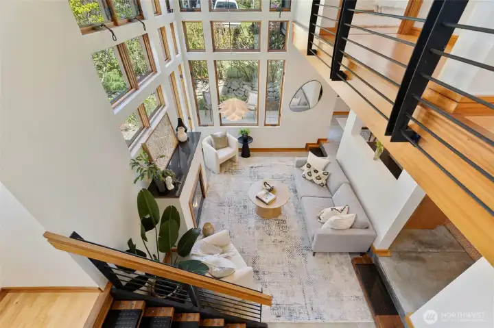 An overhead look at the living room shows the full scale of the space — the two-story window wall, fireplace, and connection to the main floor all read clearly from above.