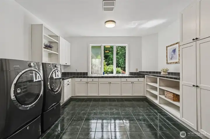 Spacious laundry room with storage and folding area Spacious laundry room with storage and folding area