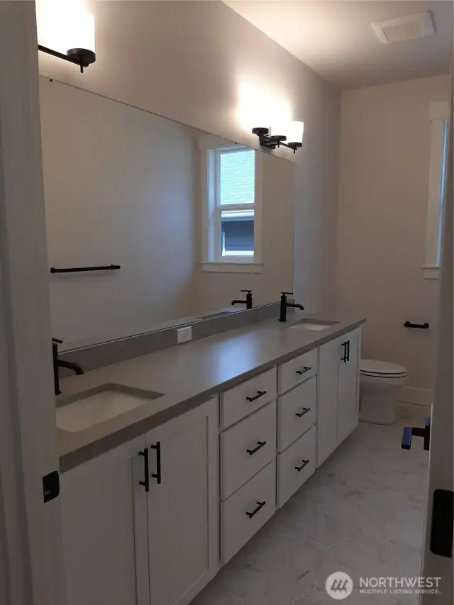 Large hall bath features dual vanity.