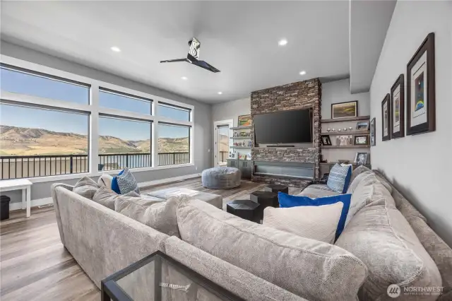 Living room with statement electric fireplace and floor to ceiling stone.