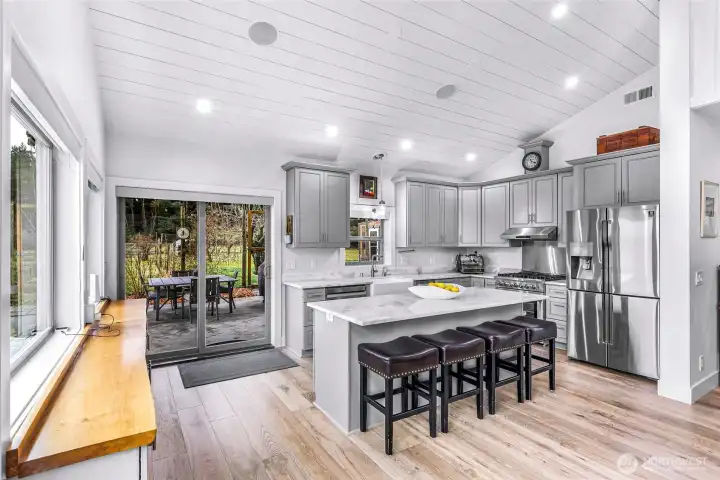 This open kitchen is an entertainers dream with built in buffet with butcher block accent top adds additional space for entertaining. Along with a large island for additional eating space. Extend the party out the sliding glass door to the covered patio over looking the beautiful garden space.