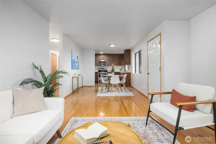 Living room, looking back to dining and kitchen. Hardwood floors.