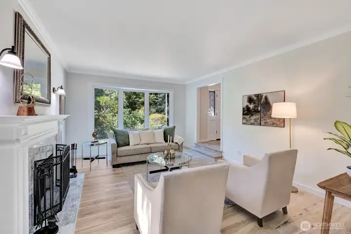 Living room has a beautiful window & marble fireplace