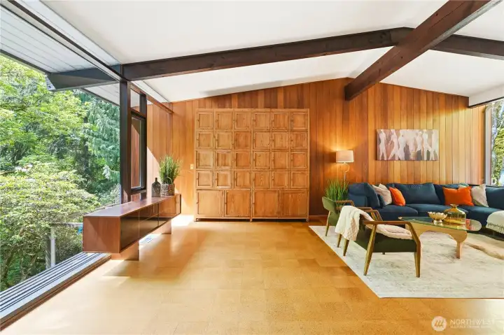 The open living area unfolds to a sweeping 9-foot wall of glass, framing a lush ravine below.