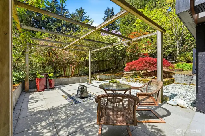 The lower patio is beautifully landscaped with space for outdoor dining or quiet enjoyment of the natural surroundings.