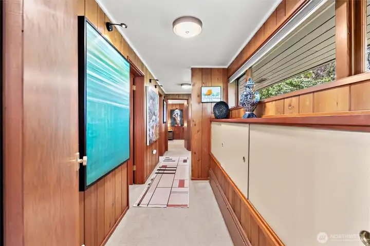 Gallery-style hallway highlights the home’s artistic character, rich wood paneling, and distinctive architectural details. Gallery-style hallway highlights the home’s artistic character, rich wood paneling, and distinctive architectural details.