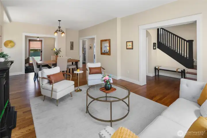 Bright living room with hardwood floors, opens up to dining space.