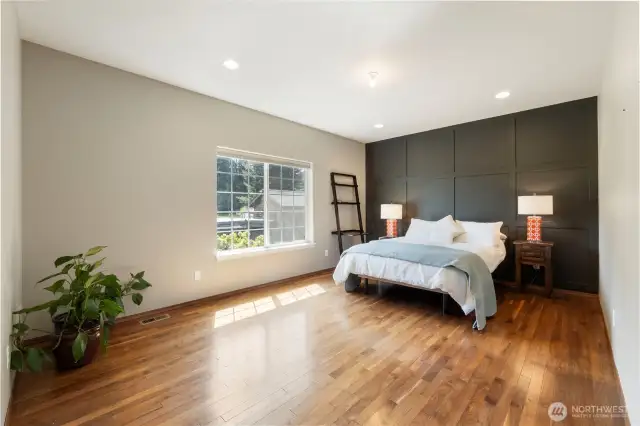Beautiful hardwoods continue throughout the Primary suite. View of the gardens, recessed can lighting, accent wall, private bathroom and walk-in closet are a few of the features in this private suite.