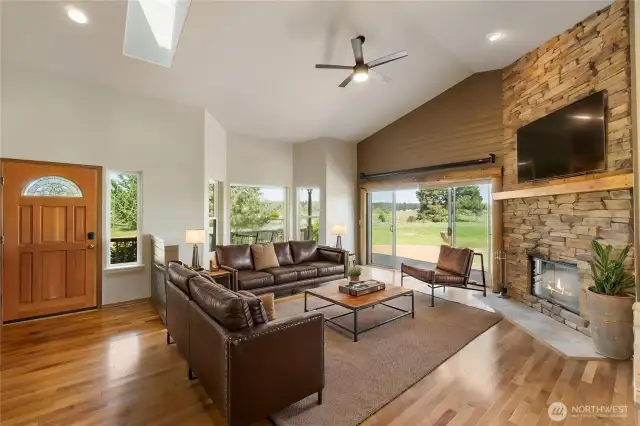 As you enter, the great room welcomes you with soaring ceilings and an impressive full-height stone fireplace that anchors the space with warmth and character. A wall of glass, including a large sliding door, seamlessly connects the indoors to the expansive deck—framing the mountain views and inviting natural light to pour in.