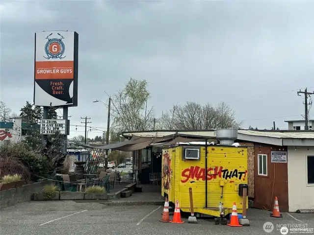 Growler guys is about 500 yards away, down Lake City Way. Fun spot with a sunny outdoor area as well as food trucks and rotating taps.