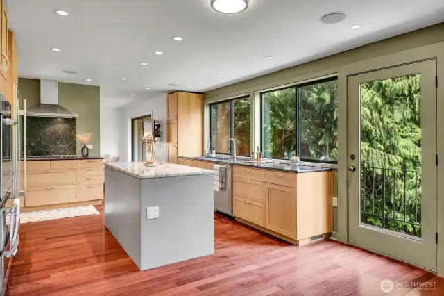 Kitchen with granite counters and Brazilian cherry hardwood floors opens to a deck overlooking the back patio and Allen Creek.
