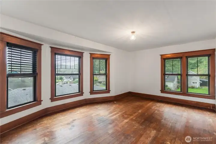 Primary room with multiple windows letting in natural light